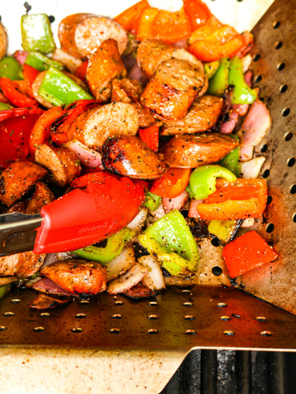 Sausage, peppers, and onions in a grill basket